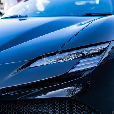 Close-up view of a sleek, black sports car's headlight and front grille.