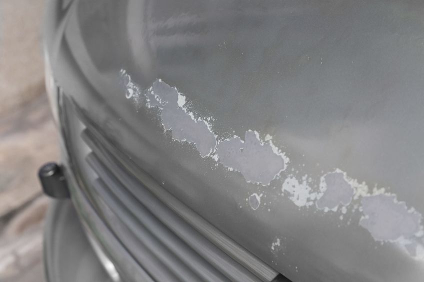 Closeup of a car that's paint is cracked and peeling